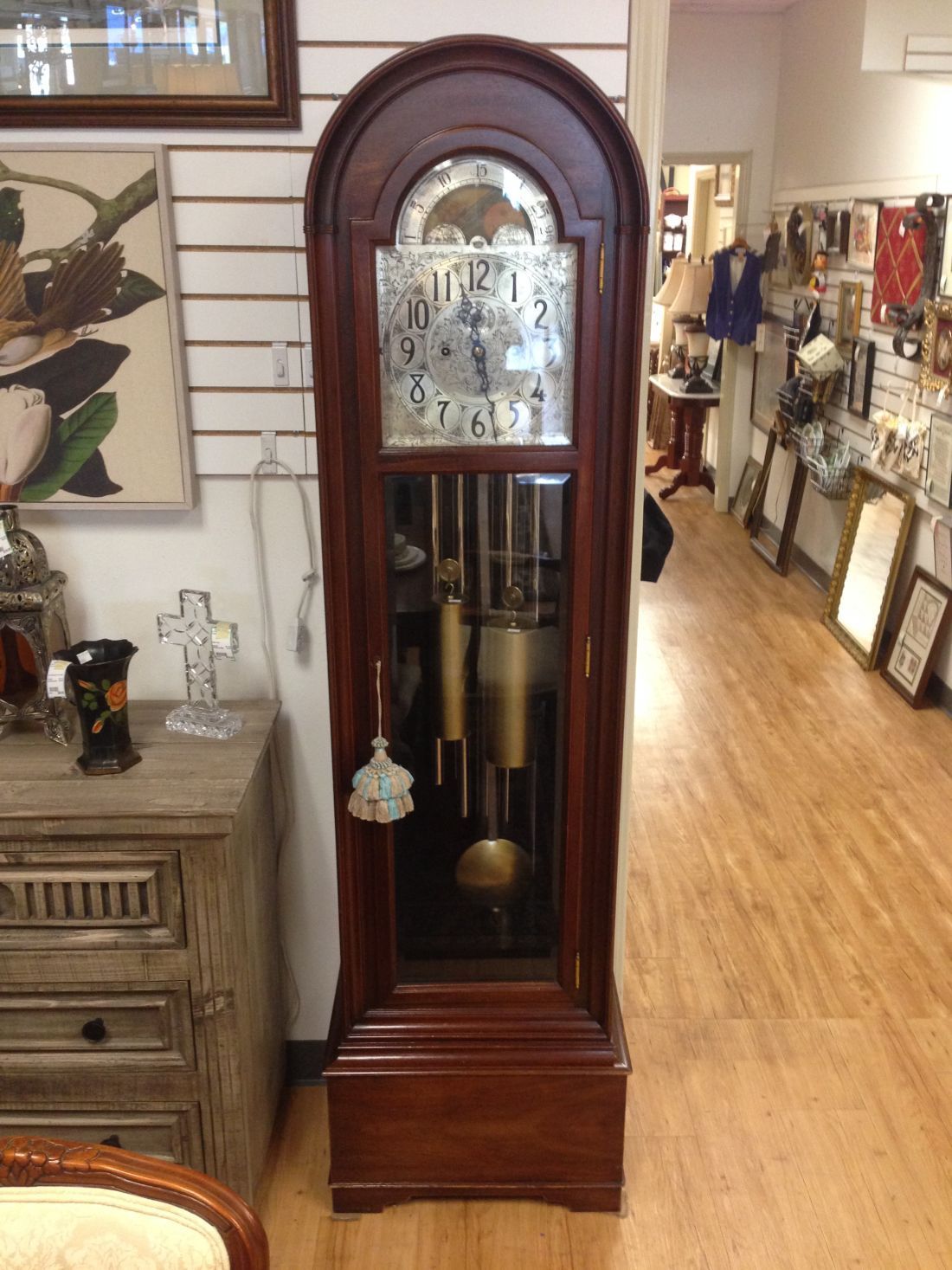 A grandfather clock is sitting on a wooden floor in a room.
