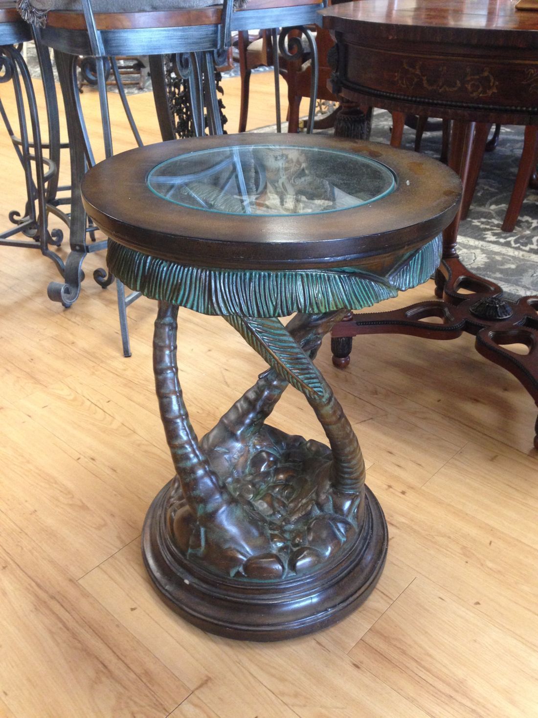 A small table with a glass top is sitting on a wooden floor.