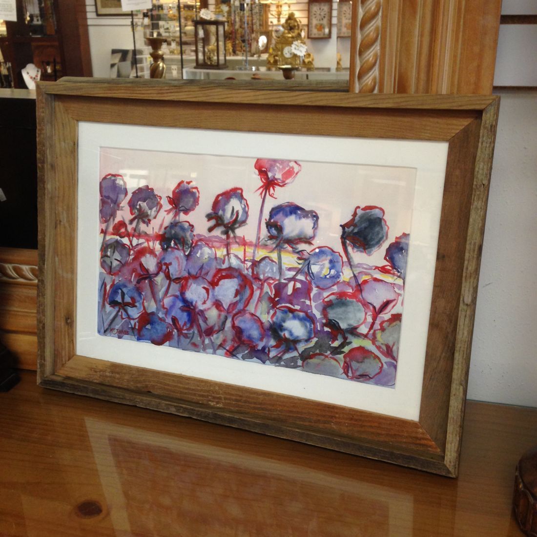 A framed painting of flowers on a table