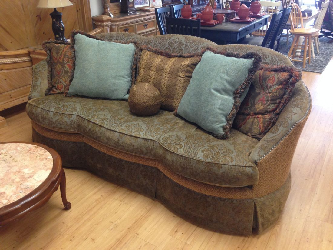 A couch with blue pillows and a table in the background