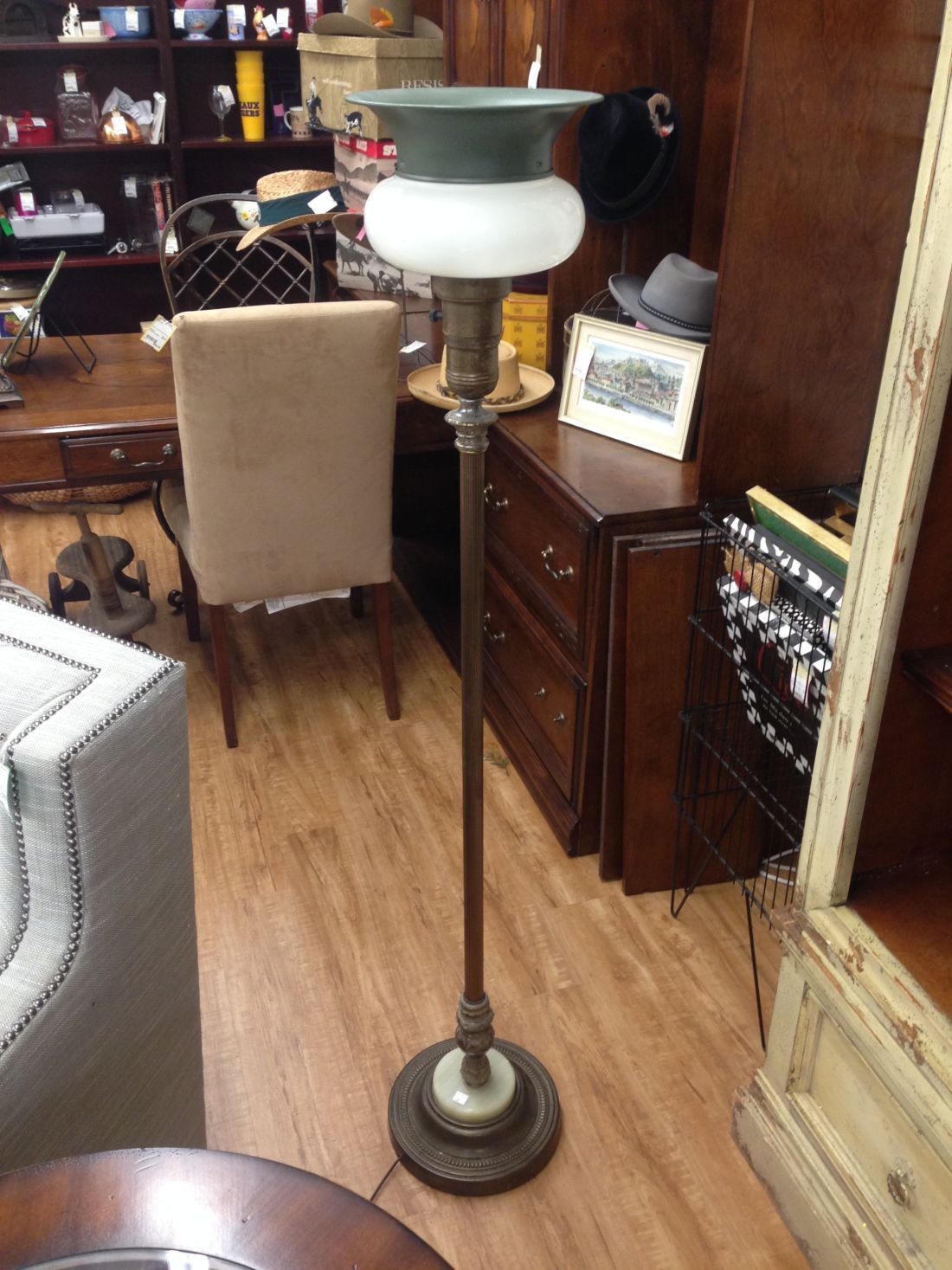 A lamp with a white glass shade is in a living room