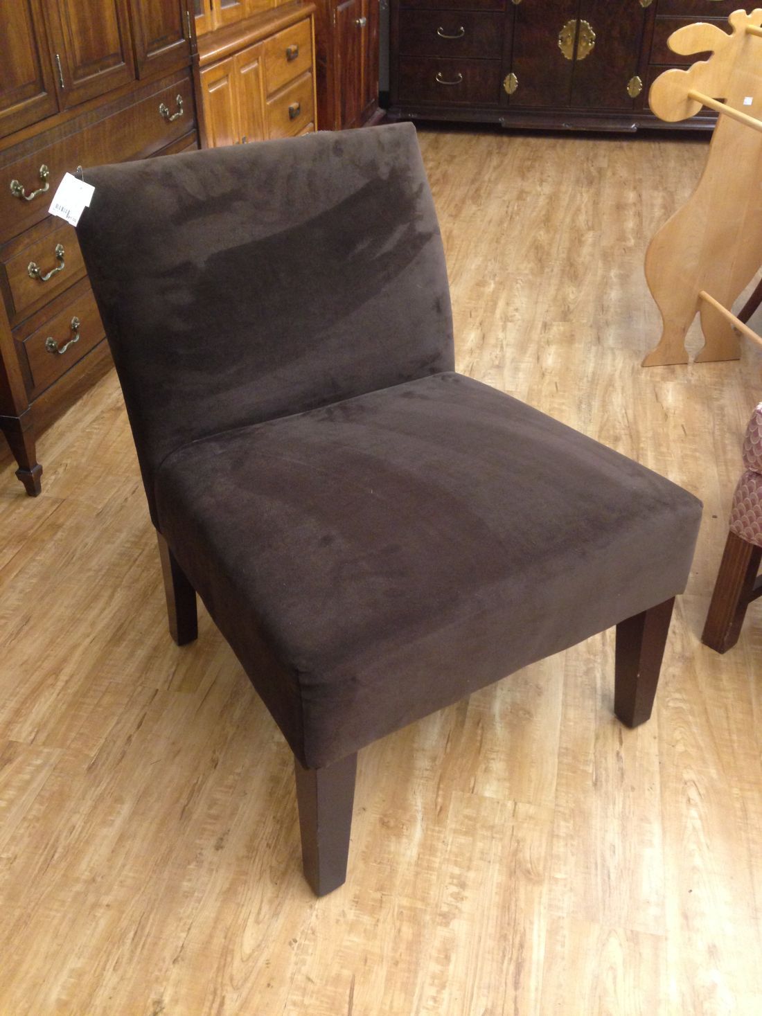 A black chair is sitting on a wooden floor in a room.