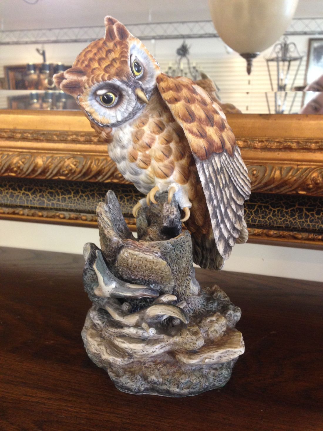 A statue of an owl sitting on top of a rock.