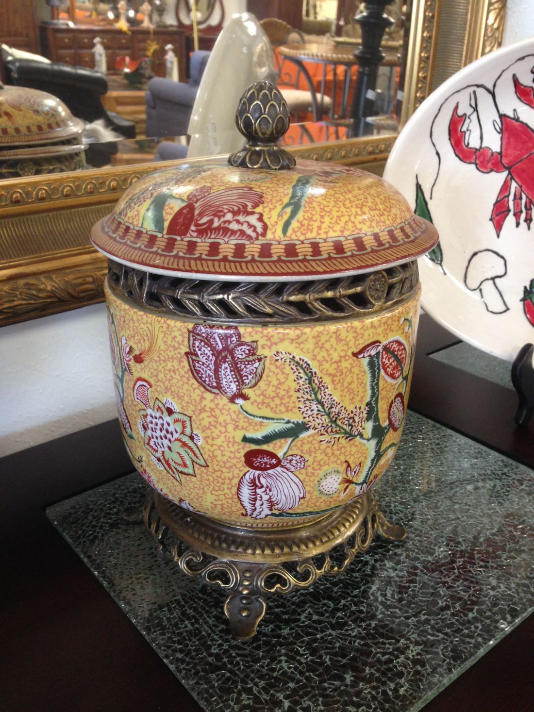 A container with a lid is sitting on a table next to a plate with a lobster on it.