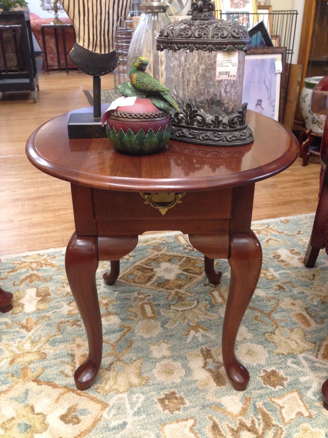 A small wooden table with a lantern on top of it in a room.