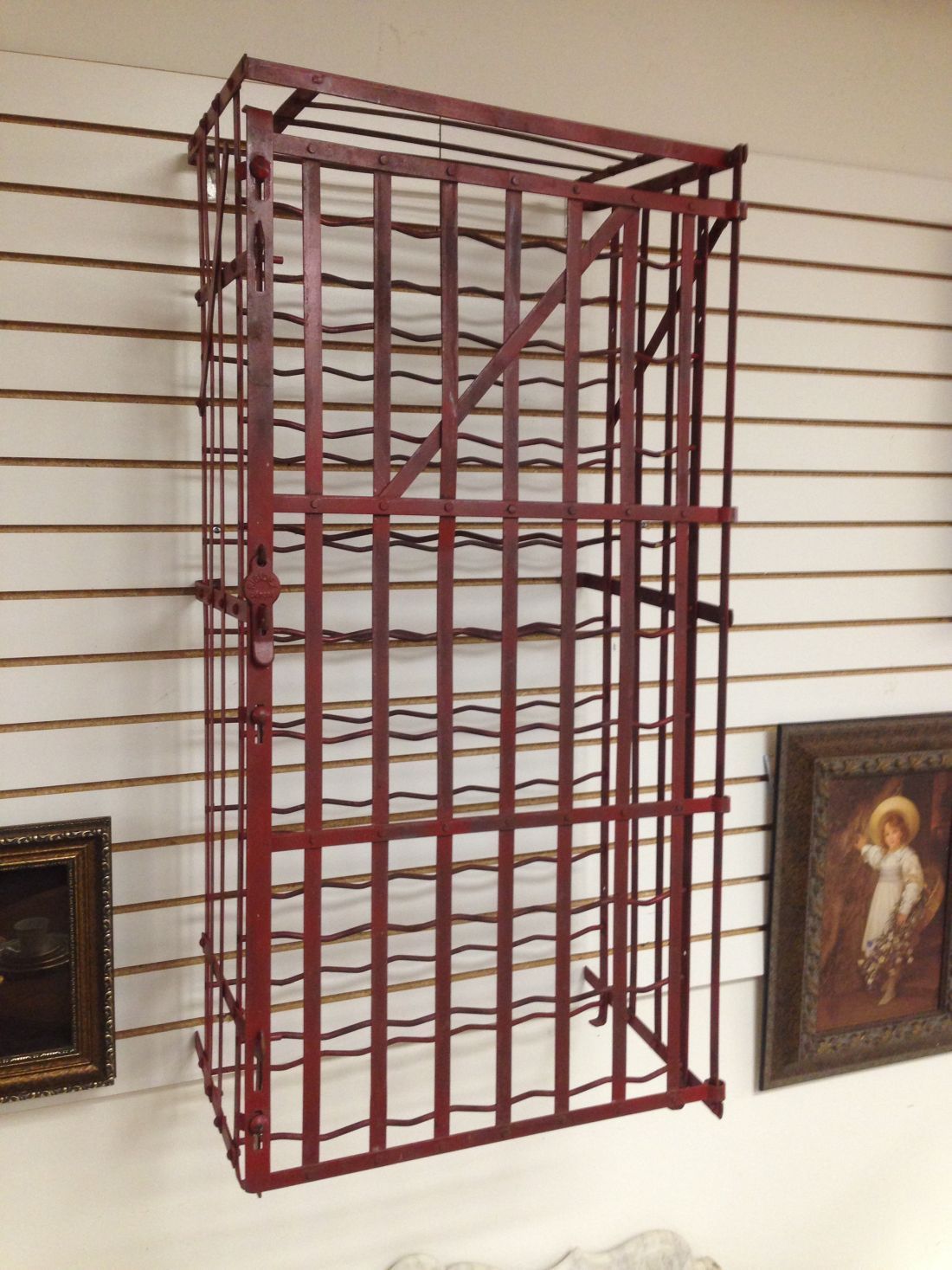 A red wine rack is hanging on a wall