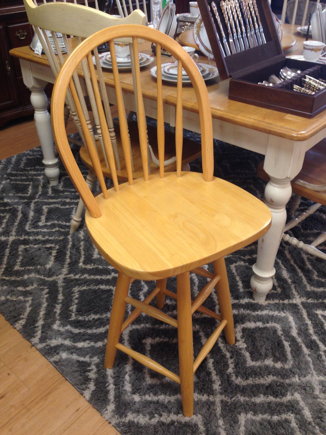 A wooden chair is sitting on a rug in front of a table