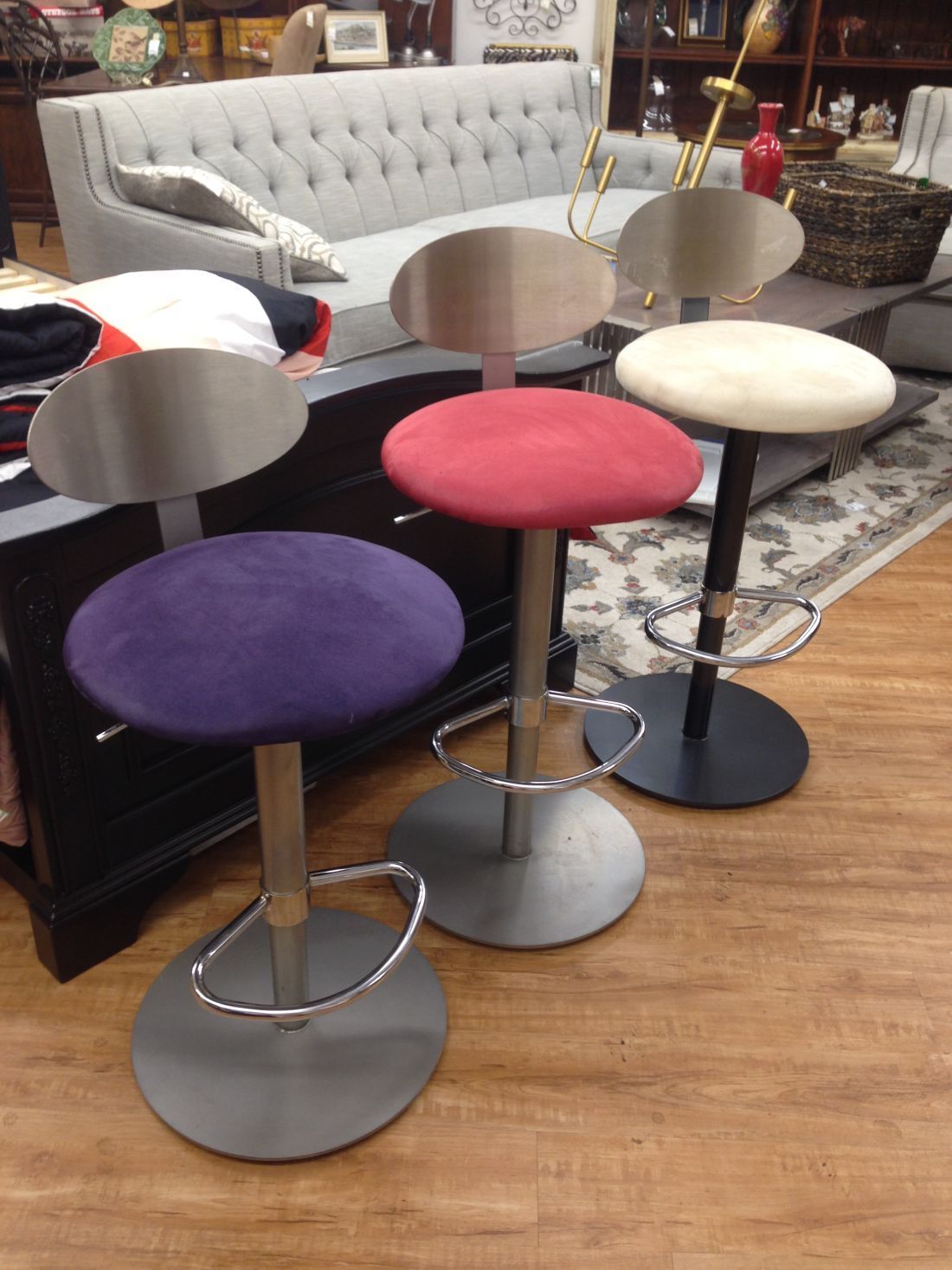 Three bar stools are sitting in a living room next to a couch