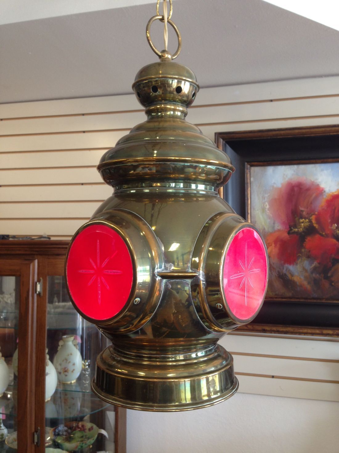 A brass lantern with red lights hanging from the ceiling