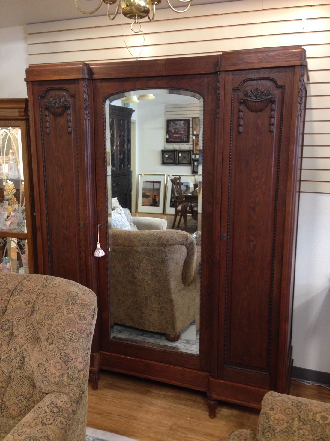 A living room with a large wooden wardrobe with a mirror