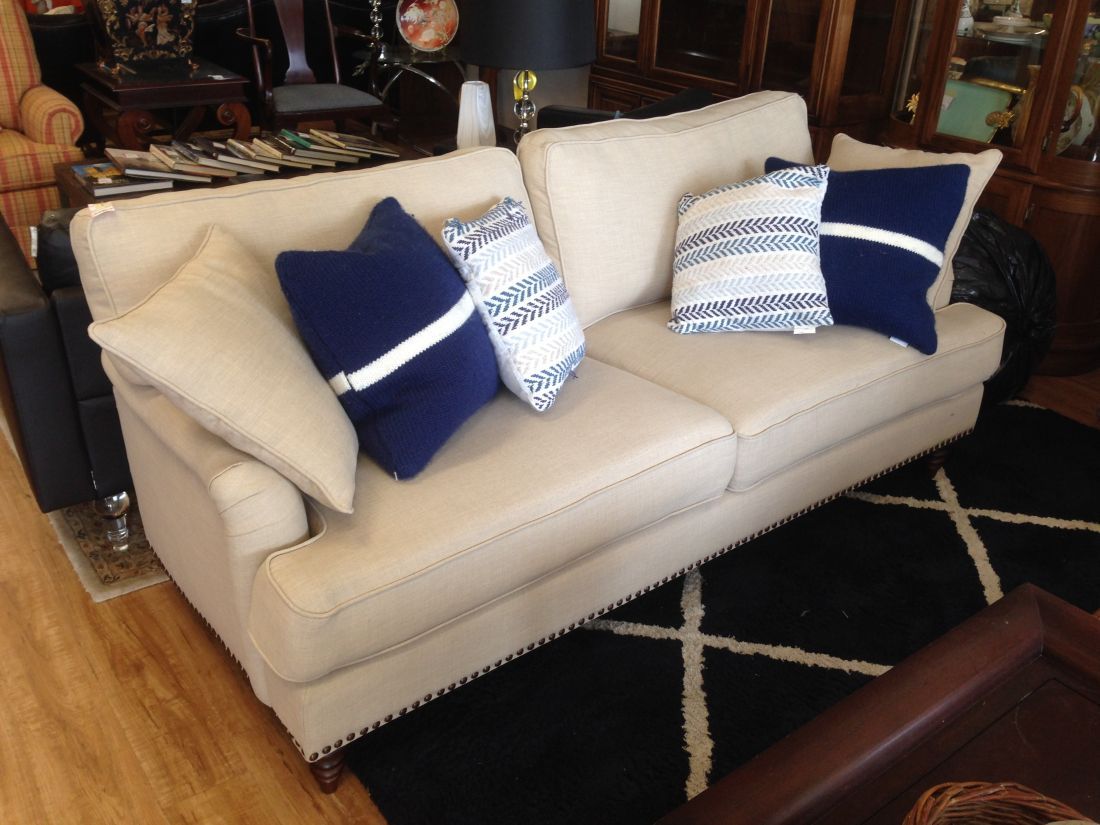 A white couch with blue pillows on it in a living room