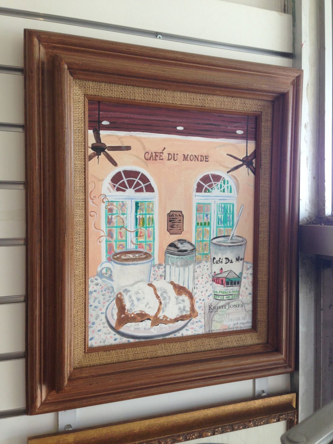 A framed painting of a restaurant with a plate of food