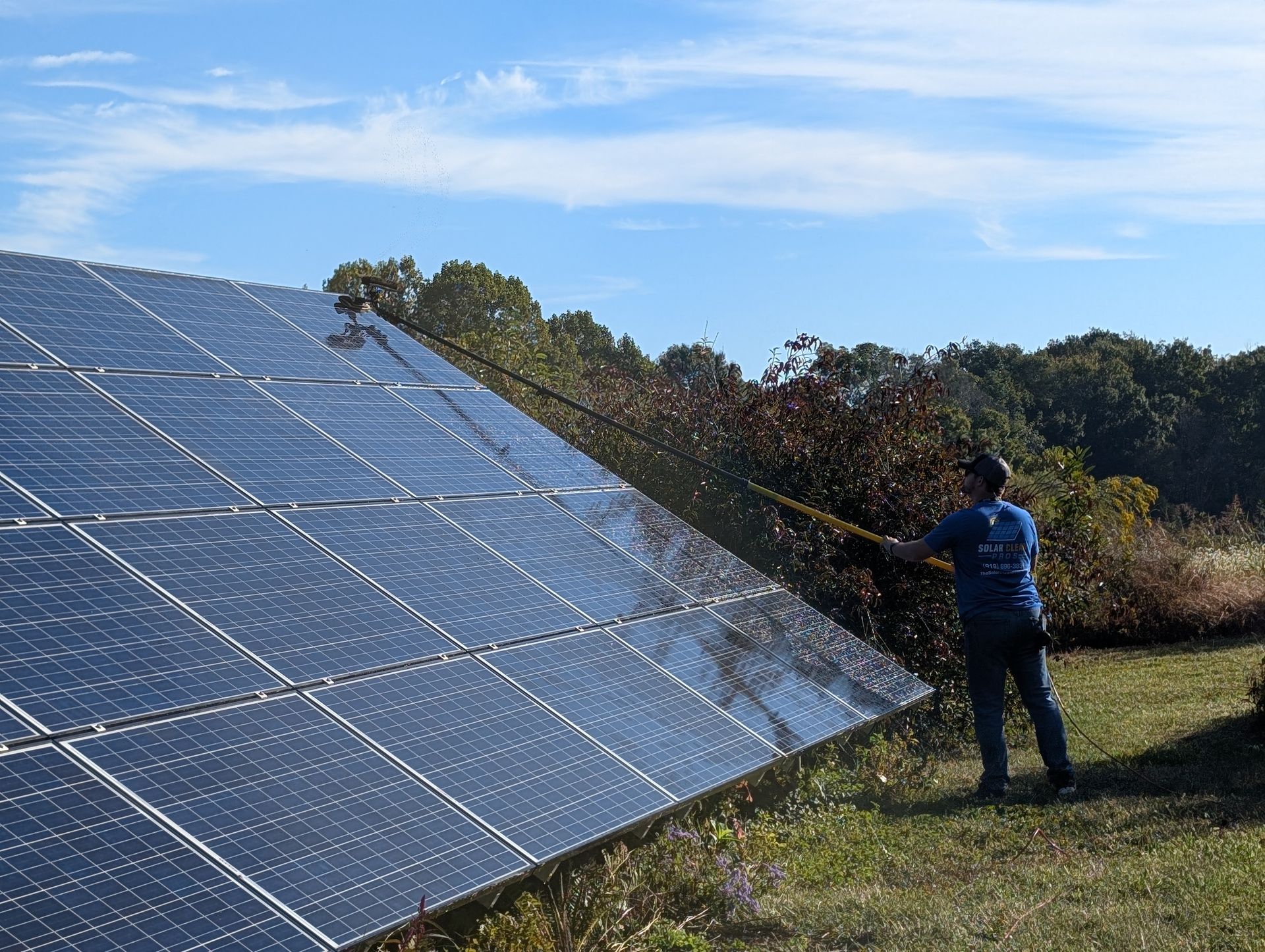 Solar Clean Pros tech cleaning a ground mounted solar system