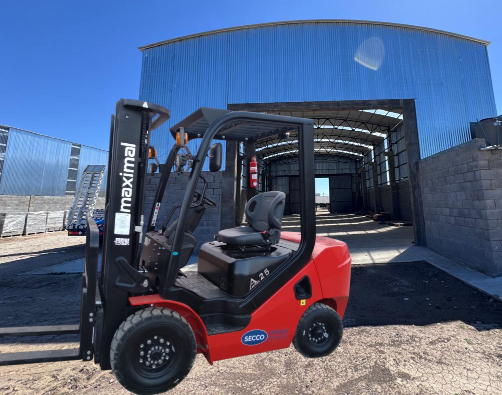 Carretilla elevadora Maximal roja estacionada frente a un edificio industrial azul bajo un cielo brillante.