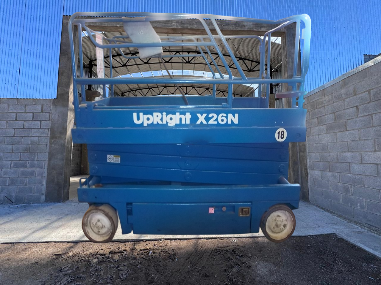 Elevador de tijera Blue UpRight X26N en un área de construcción.