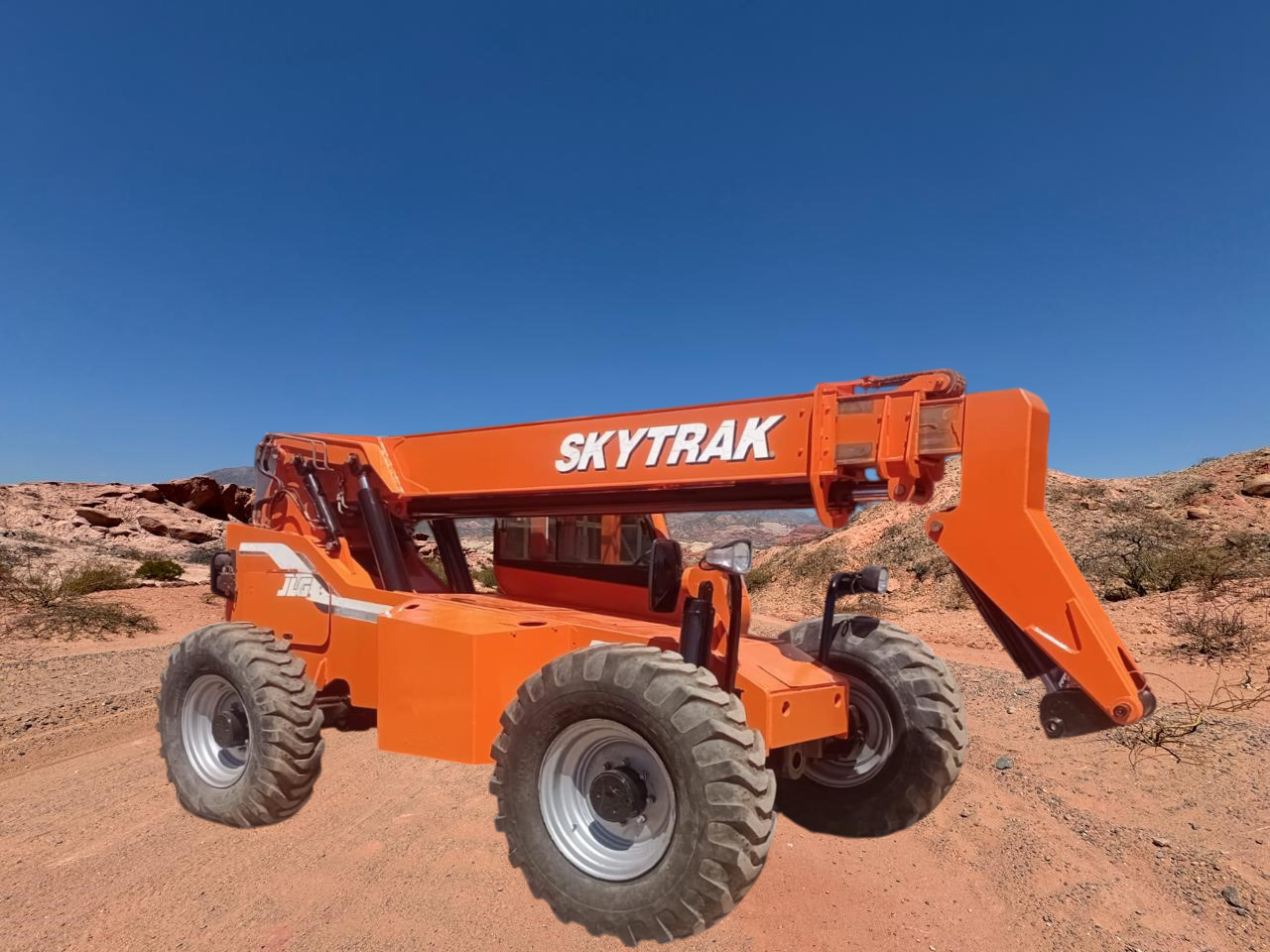Manipulador telescópico Skytrak naranja en un paisaje desértico con cielo azul.