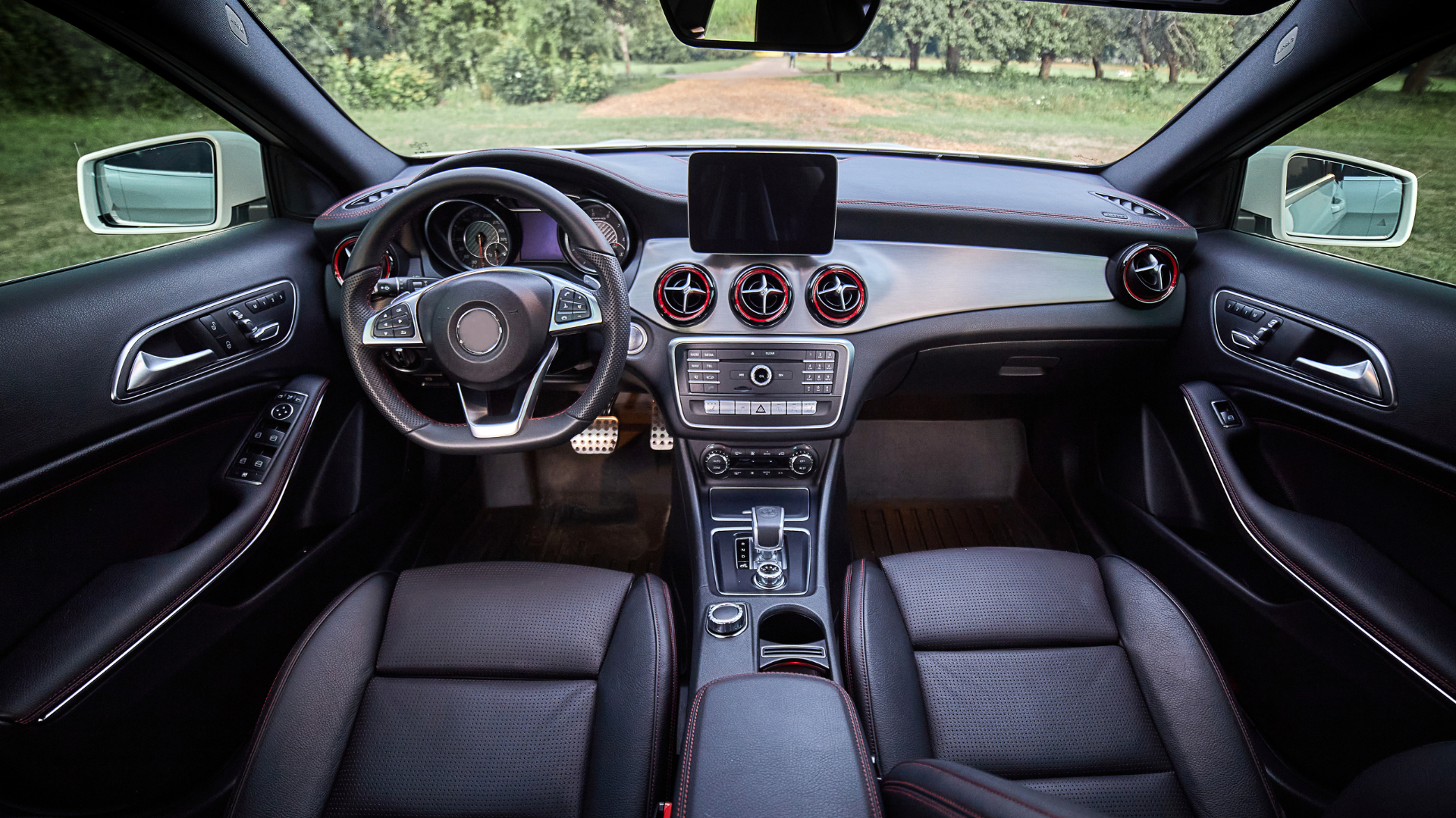 The interior of a car with black leather seats and a steering wheel.
