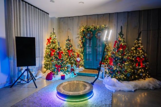 A room filled with christmas trees and a photo booth.