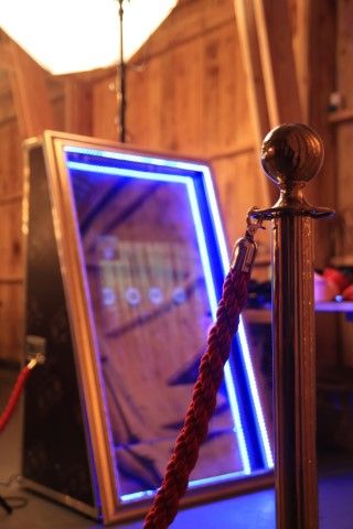 A large mirror is sitting next to a red rope barrier.