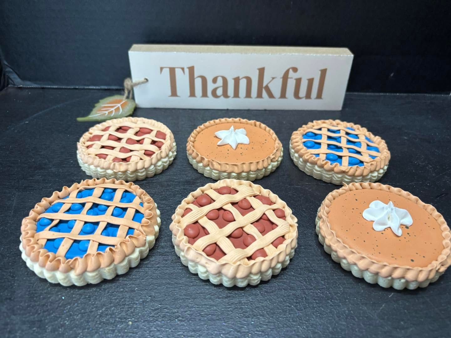 Thankful sign behind six decorative mini pies on a dark surface