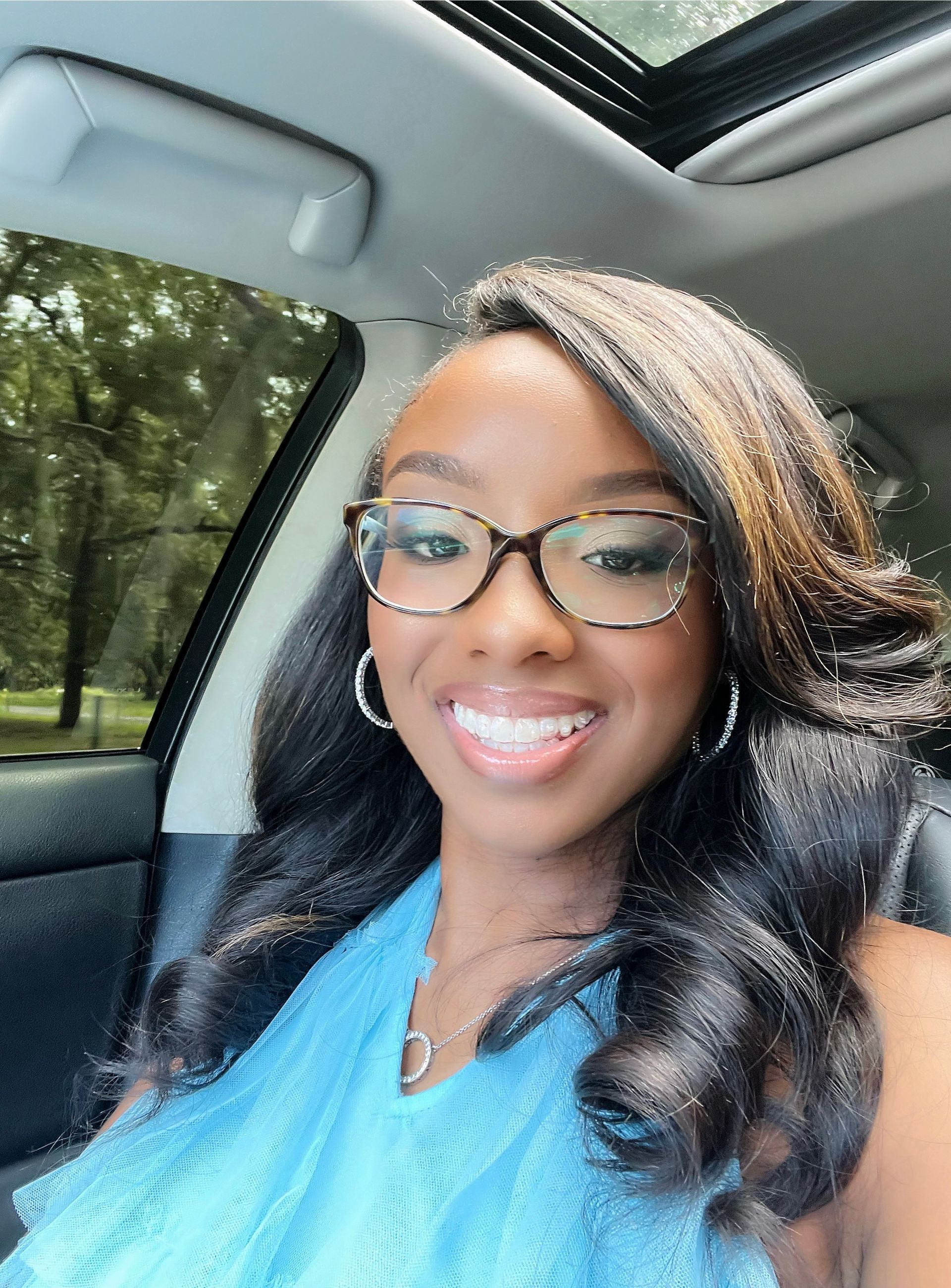A dining room with a table and chairs and a wooden staircase.