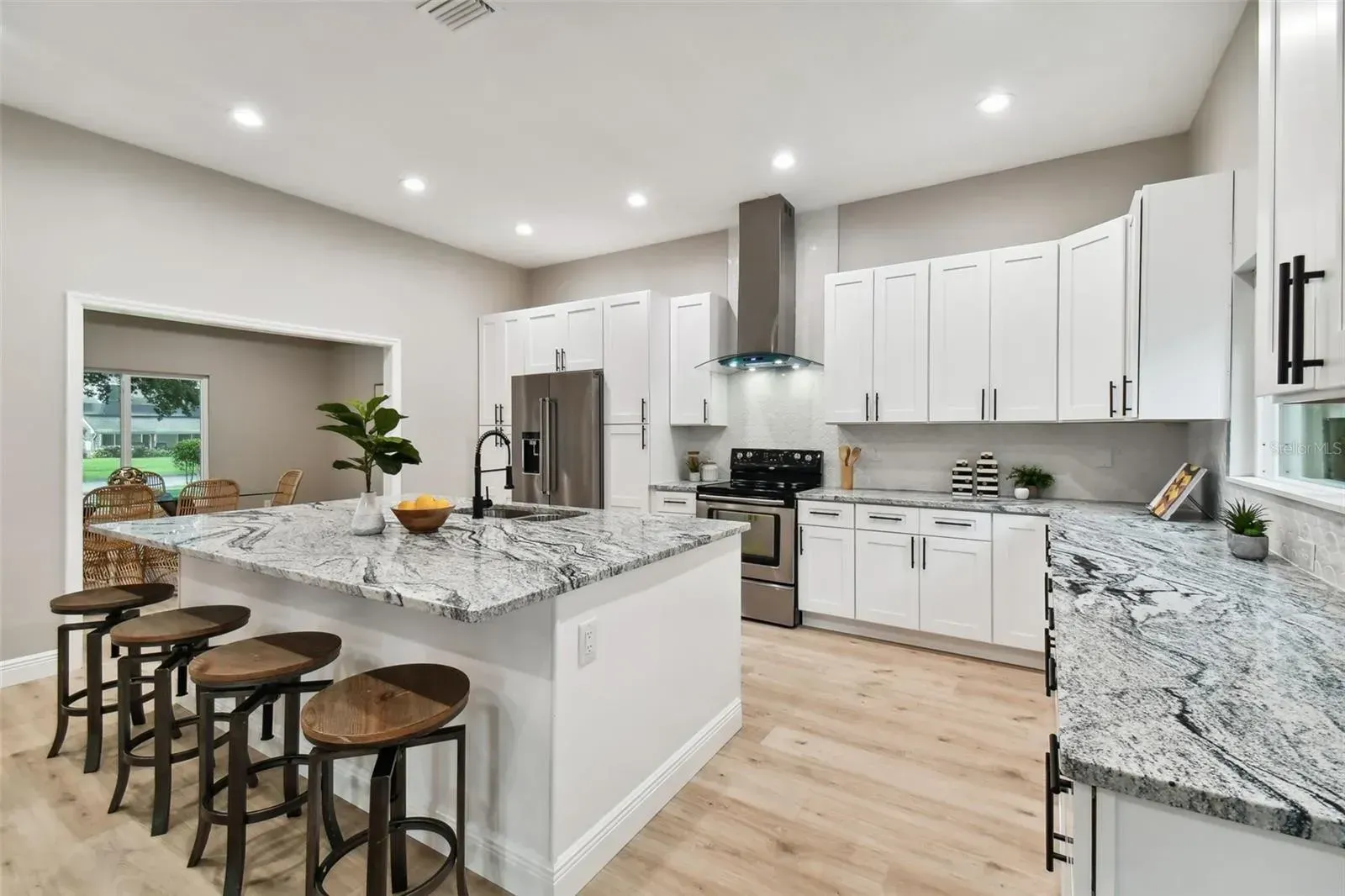 A kitchen with white cabinets and a large island in the middle.