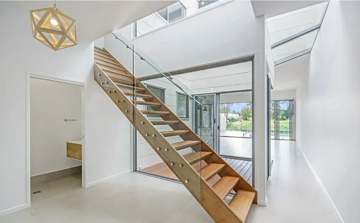 A Wooden Staircase With a Glass Railing in a Hallway — O'Brien Painting Contractors in Maroochydore, QLD