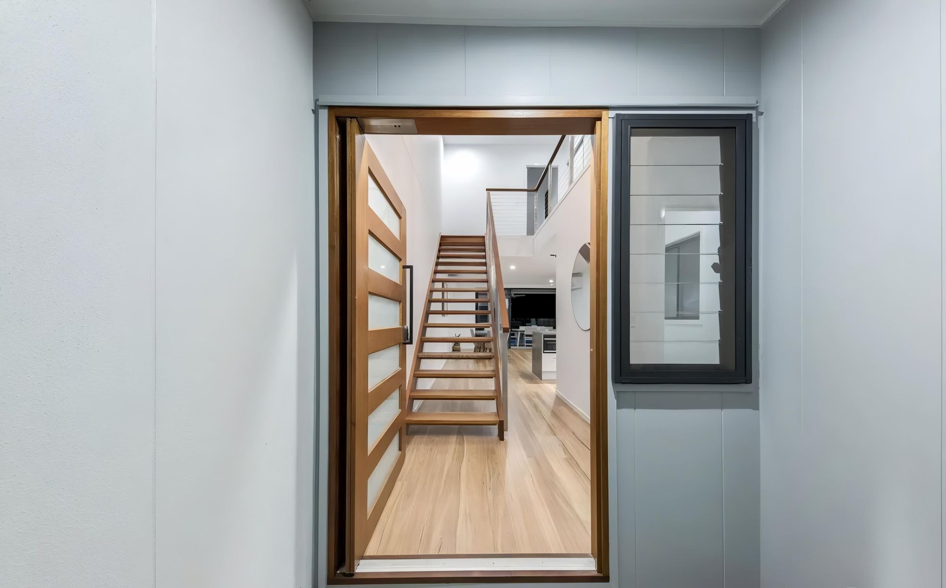 A Man is Painting a Wall With a Broom — O'Brien Painting Contractors in Mooloolaba, QLD