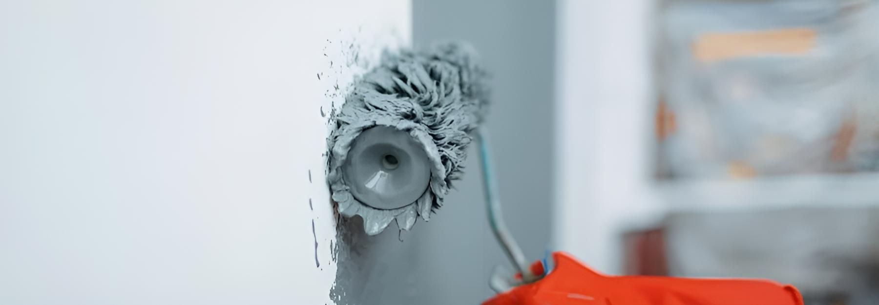 A Person is Painting a Wall With a Paint Roller — O'Brien Painting Contractors in Alexandra Headland, QLD