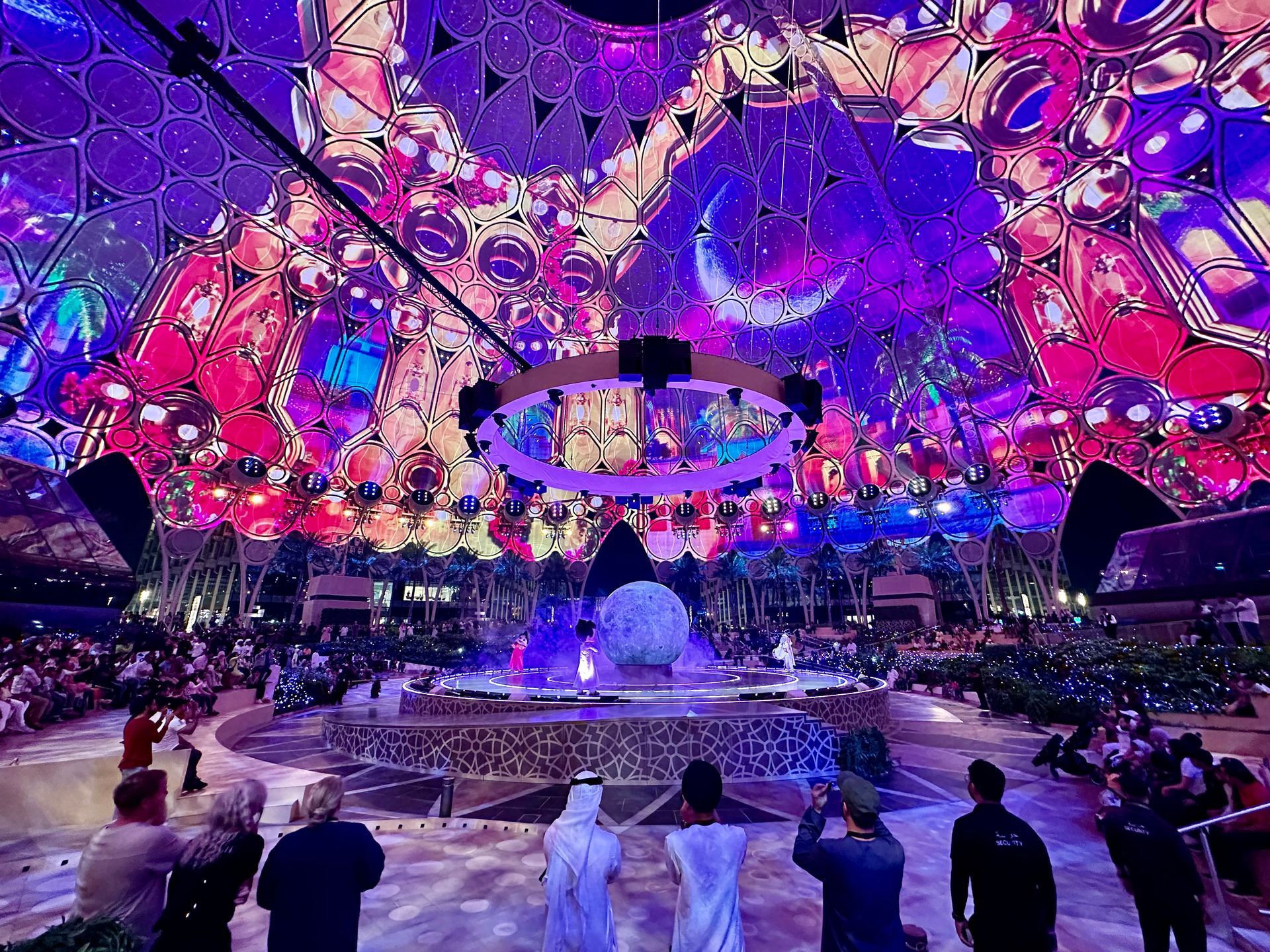 Children's Ramadan performance, in the big dome of Al Wasl Plaza, Expo City Dubai. Pinks and purples, audience young and old.