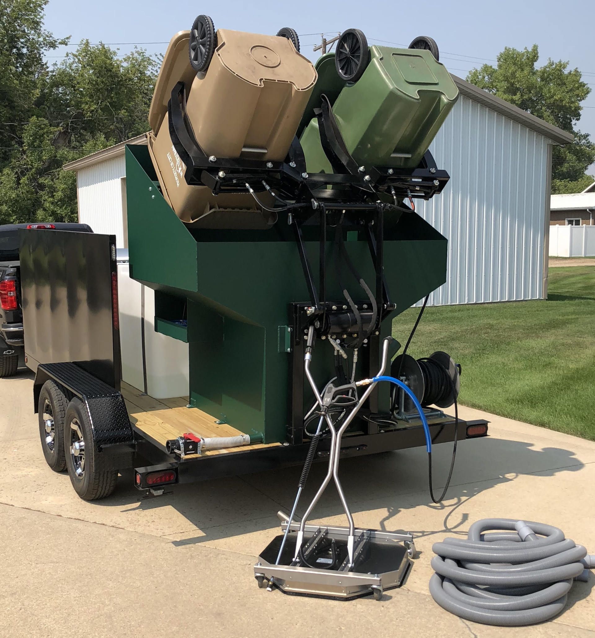 2 Bin Hopper  loading trash cans over spray heads with pressure washer