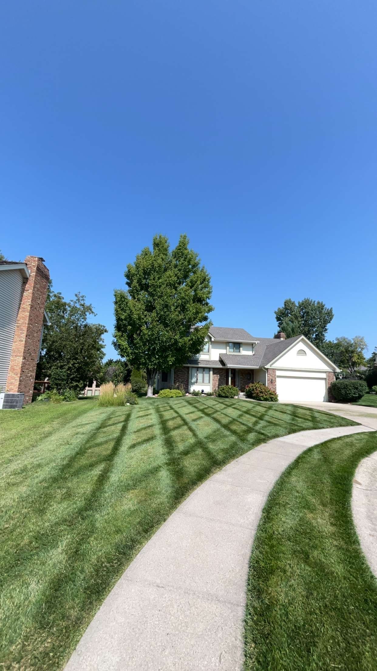 A Path Leading to a House With a Lush Green Lawn