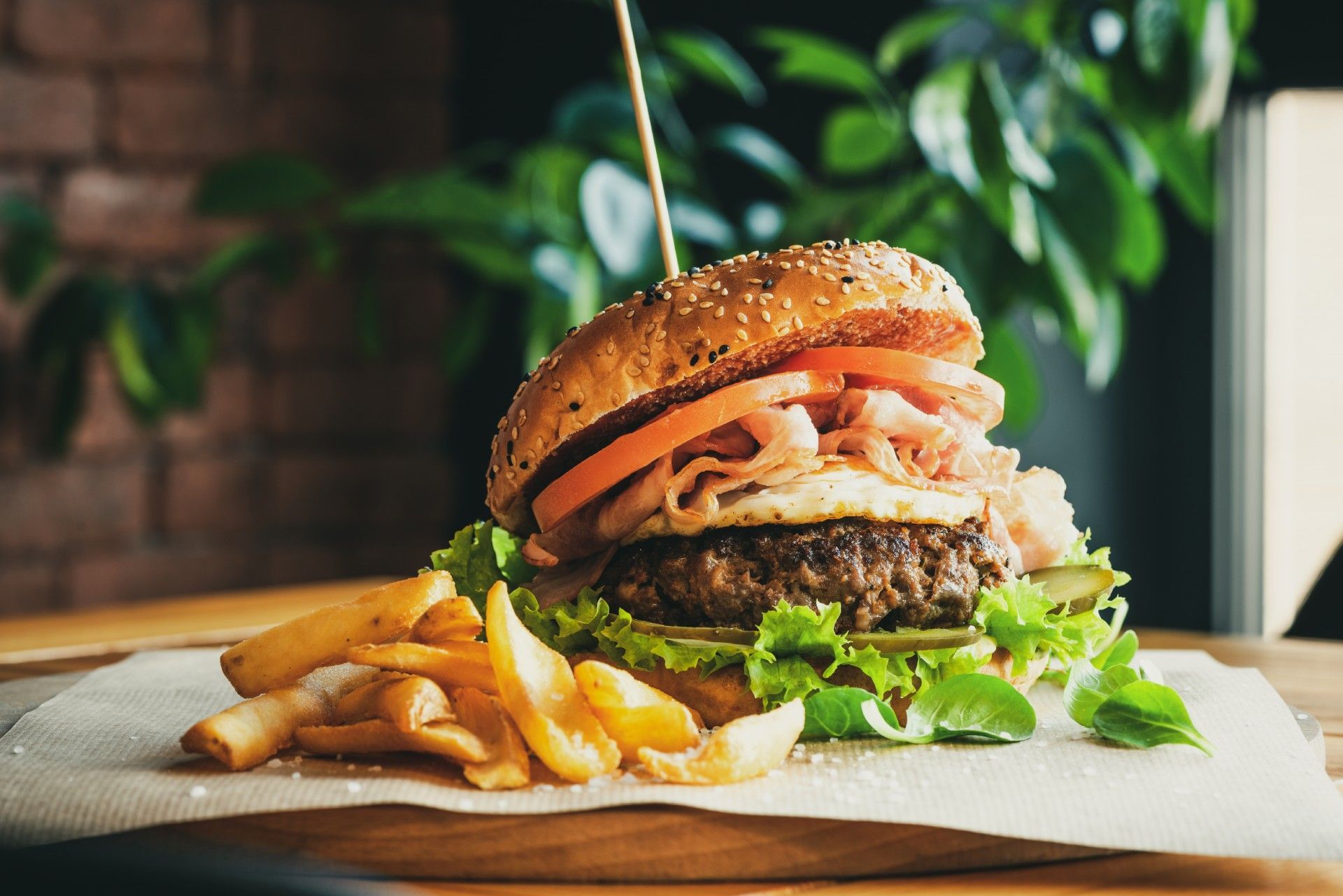 A close up of a hamburger and french fries on a table.