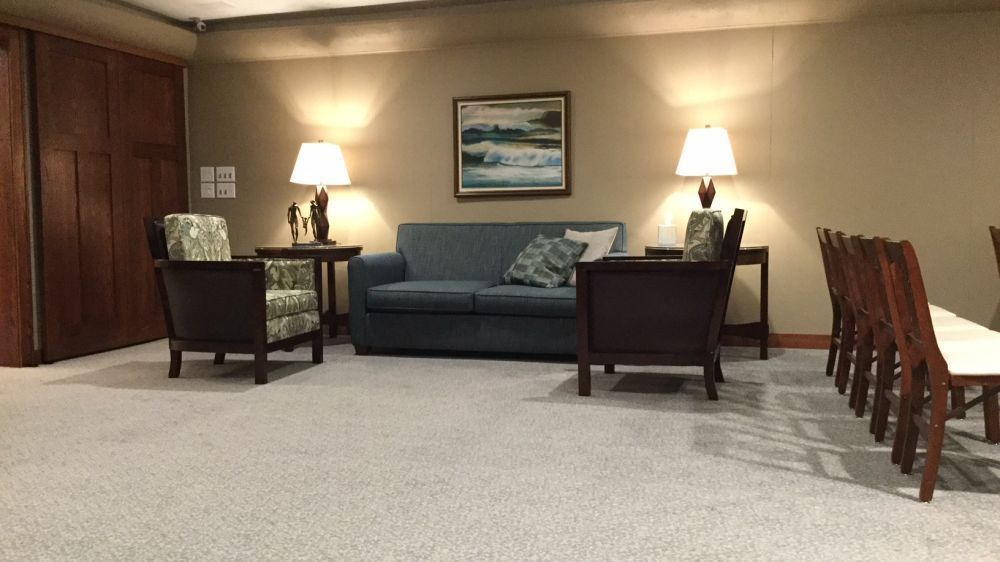 A living room with a couch , chairs and lamps