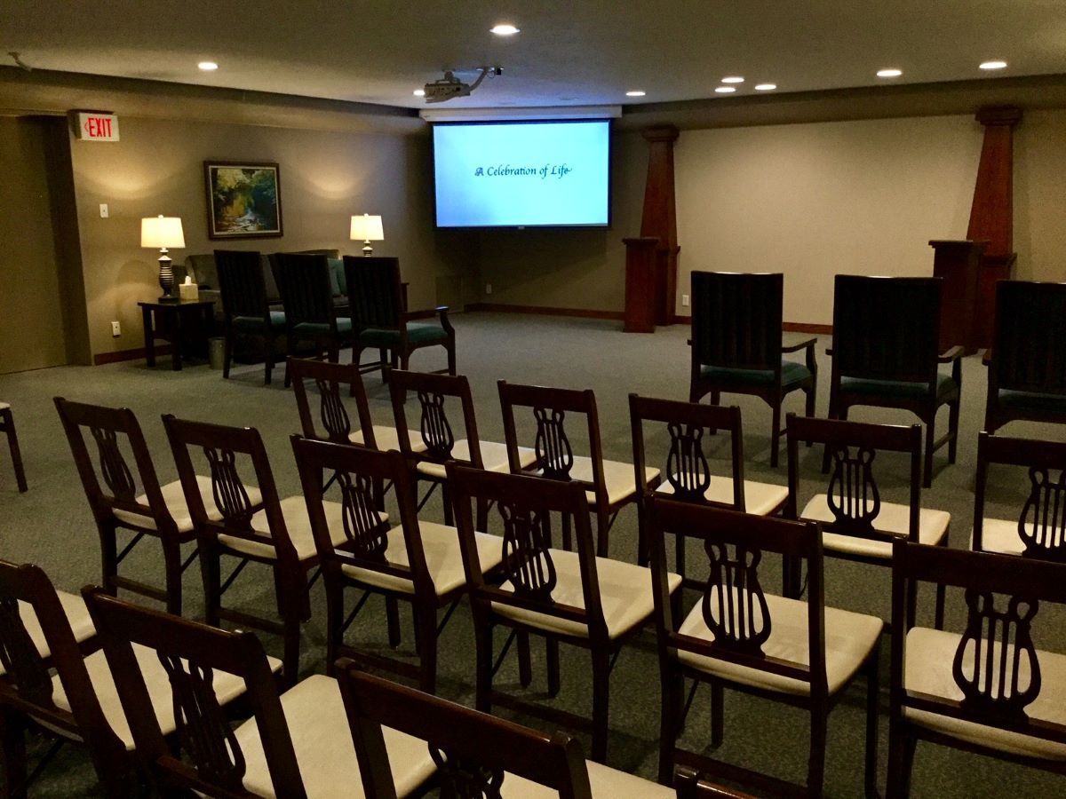 A room with rows of chairs and a projector screen