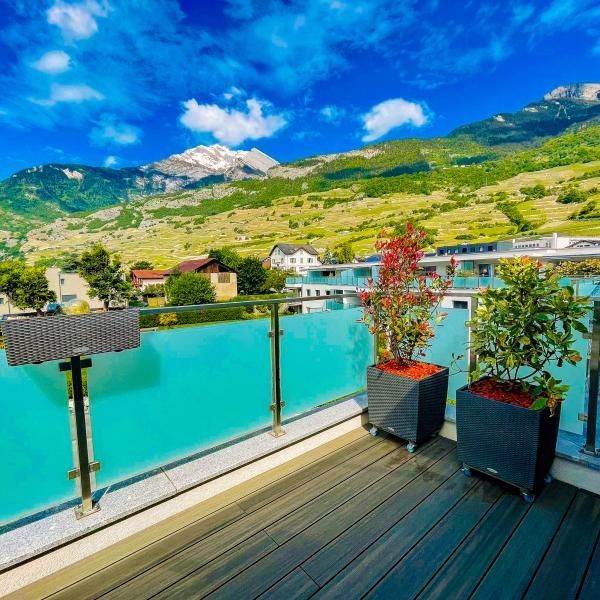 Un balcon donnant sur un plan d'eau avec des montagnes en arrière-plan