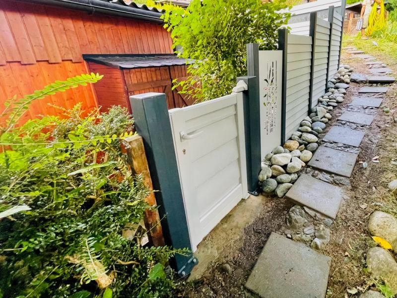 Une porte blanche se trouve à côté d'une allée en pierre.