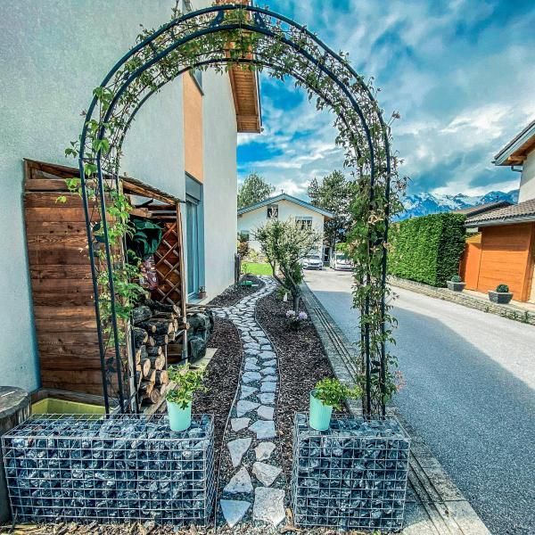 Un jardin avec une allée en pierre menant à une maison