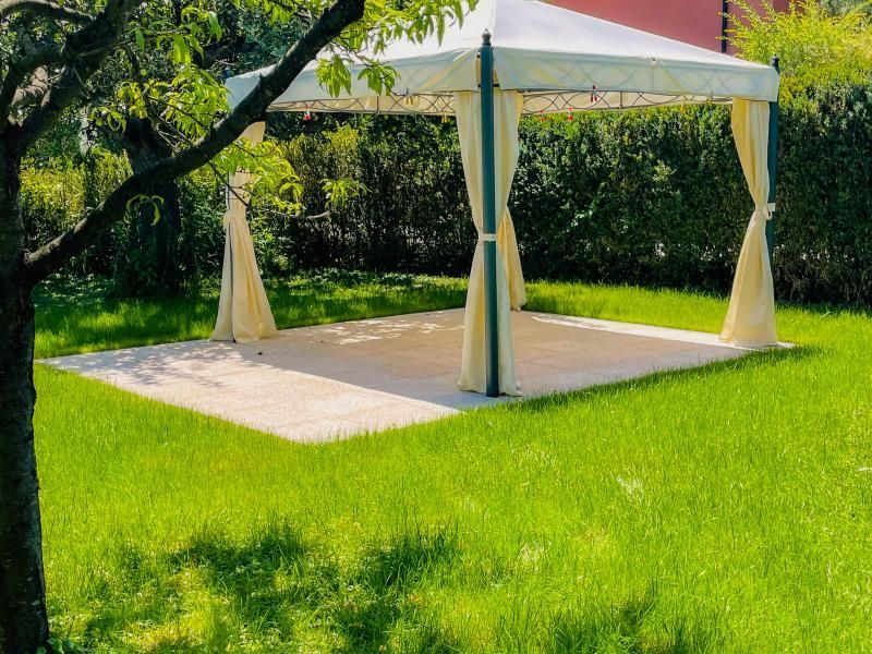 Une tente blanche est posée au milieu d'un champ vert luxuriant.