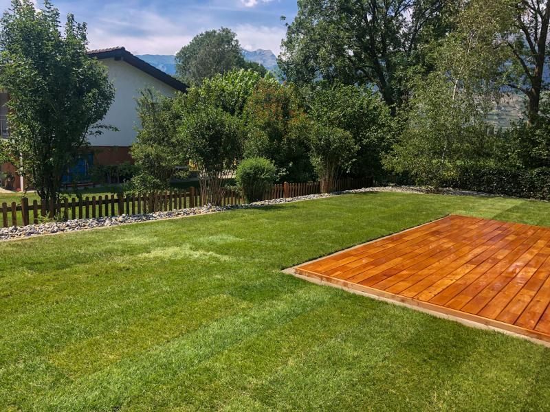 Il y a une piste de danse en bois au milieu d'un champ verdoyant.