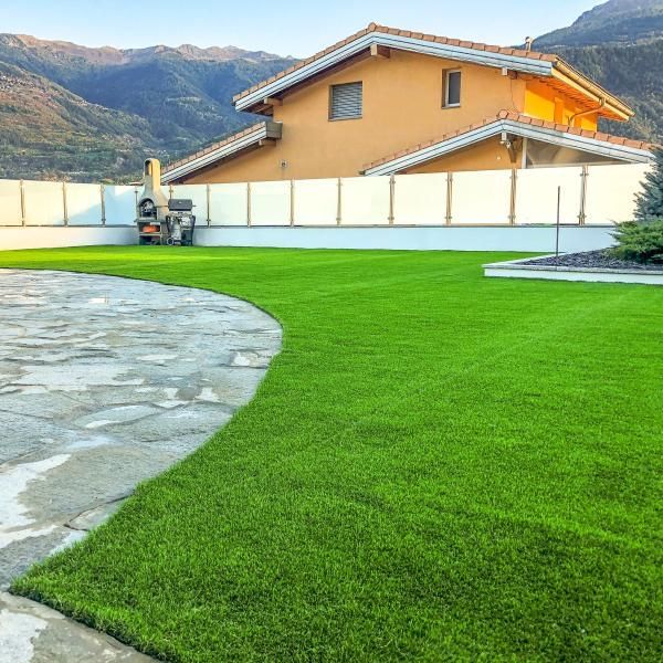 Une grande maison avec une pelouse verte luxuriante devant elle