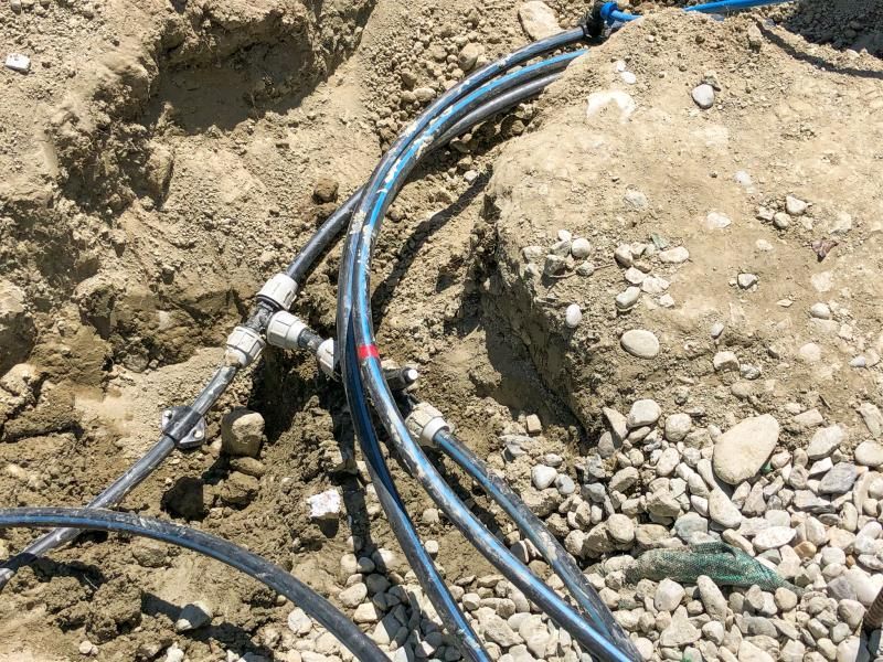 Un tas de fils électriques traînent dans la terre.