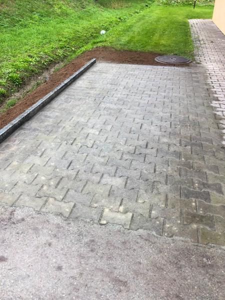 Une allée en briques menant à une zone herbeuse à côté d'un bâtiment.