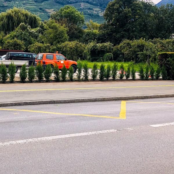 Un camion orange est garé sur le bord de la route.