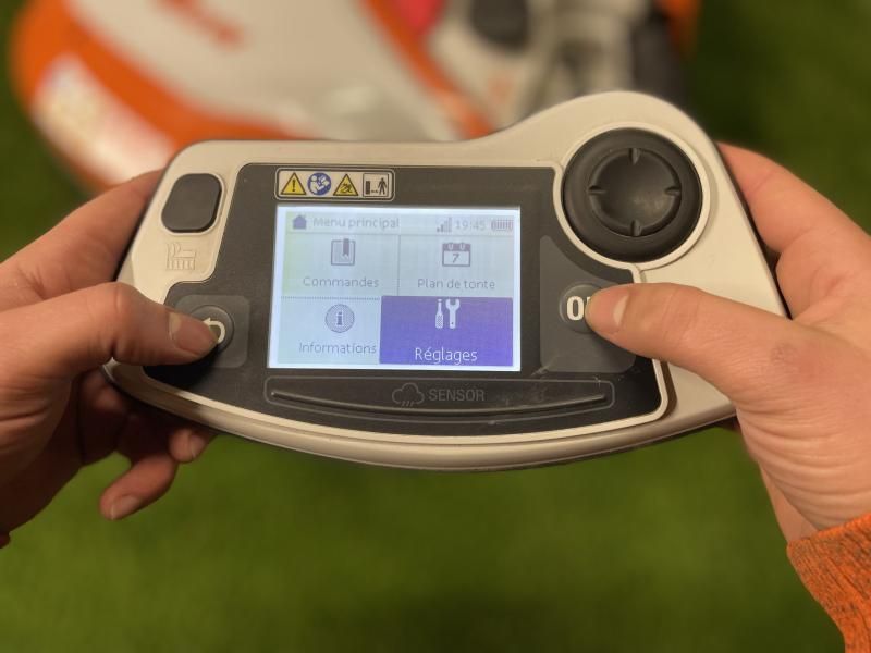 Une personne tient une télécommande dans ses mains.