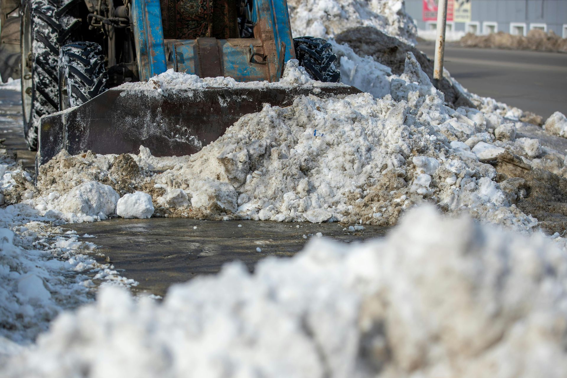 Un bulldozer déblaye la neige sur le bord de la route.