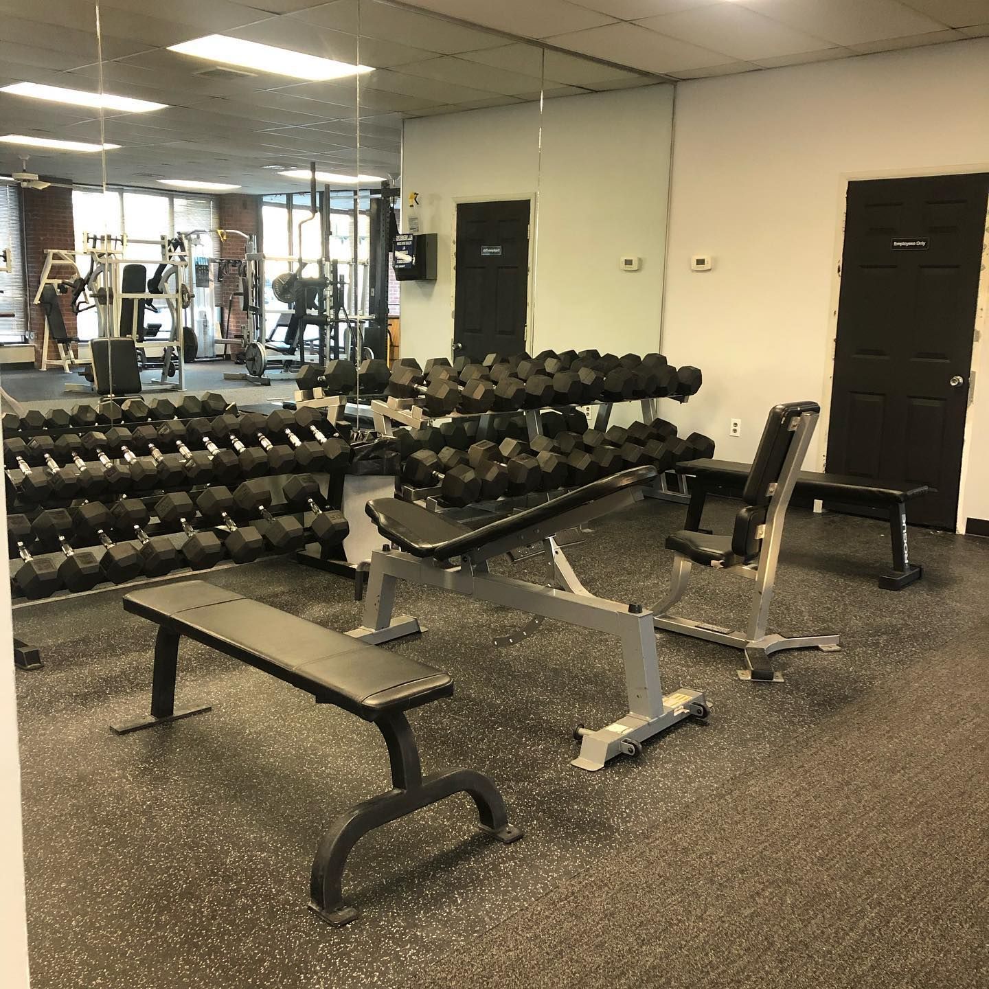 A gym with a lot of dumbbells and benches