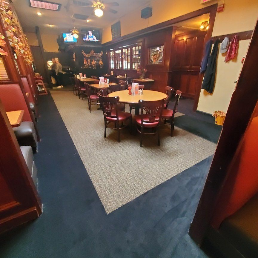 A long hallway with tables and chairs in a restaurant