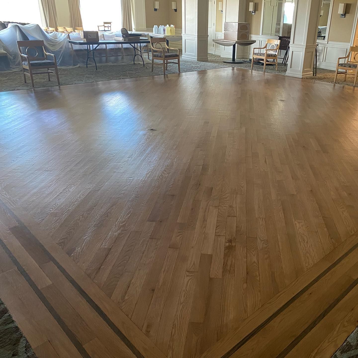 A large room with a wooden floor and chairs.