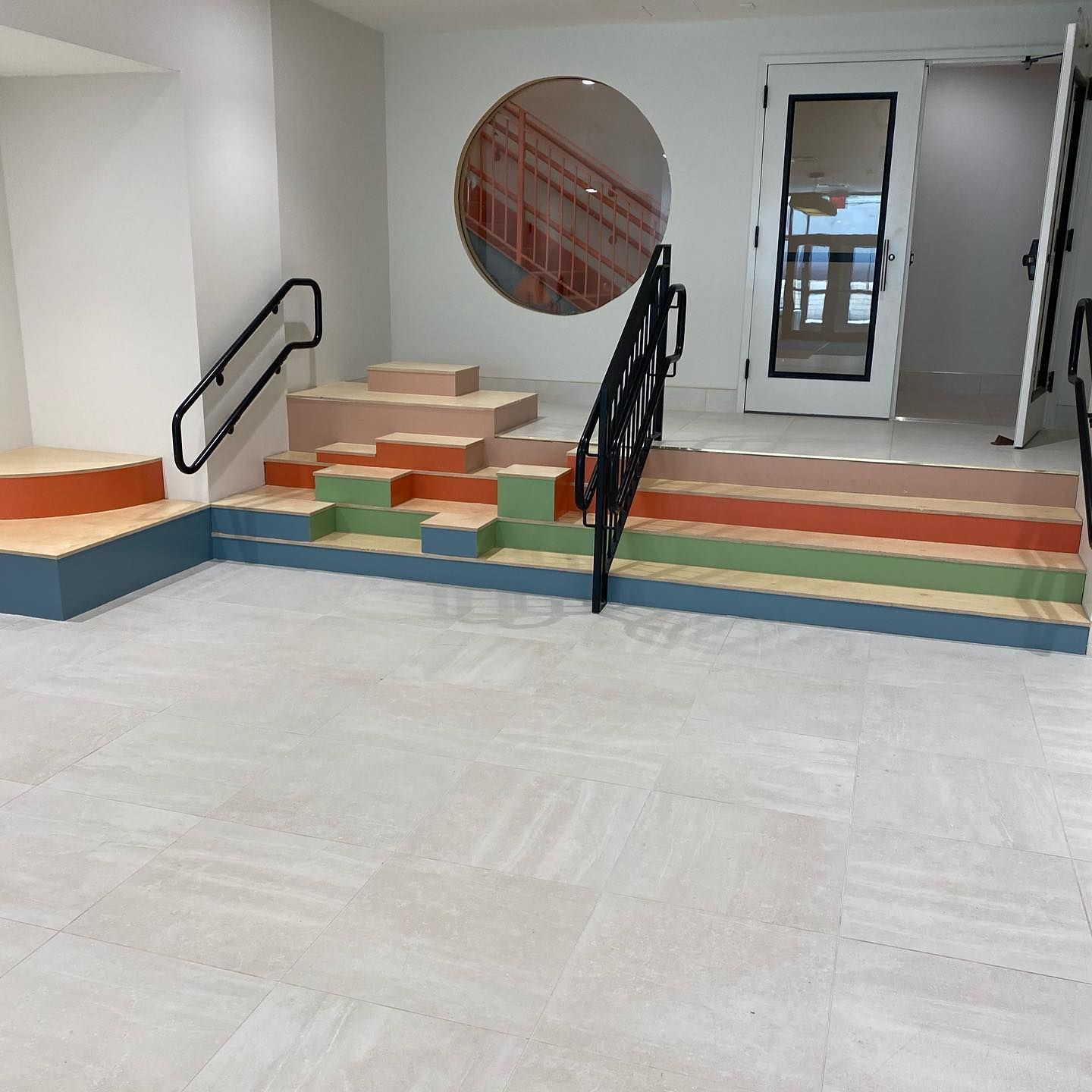 A room with stairs and a round window